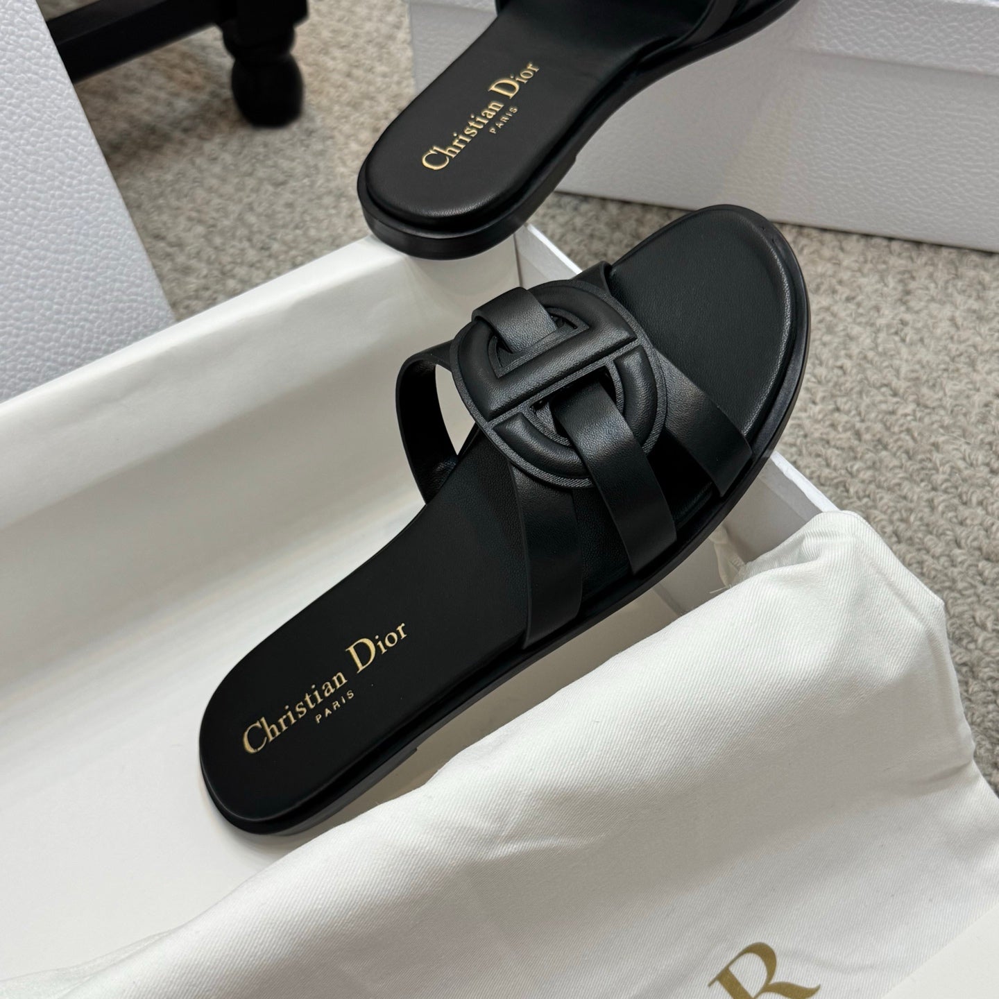 Dior black slide sandals with wide double straps and gold Christian Dior logo on footbed