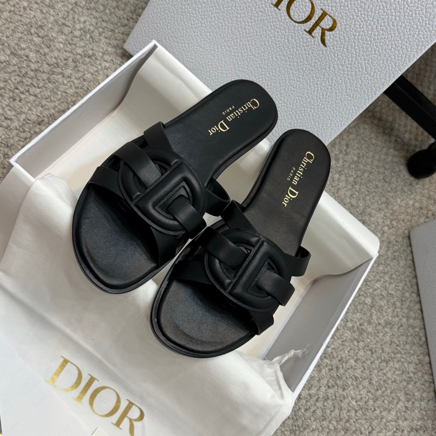 Dior black slide sandals with wide cutout-style straps and gold logo text