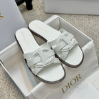 White Dior slide sandals with wide cross strap and dark edge sole