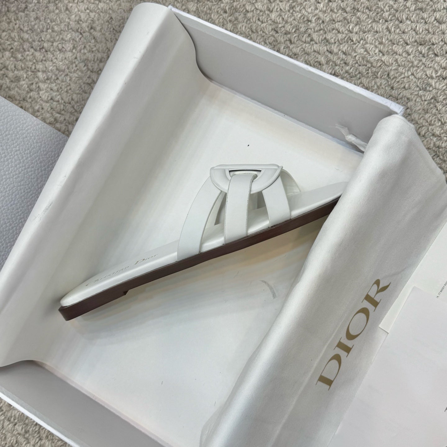 White Dior slide sandal displayed in box with wide front strap