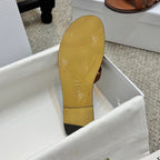 Brown leather Dior slide sandal outsole with embossed logo and small motif marks