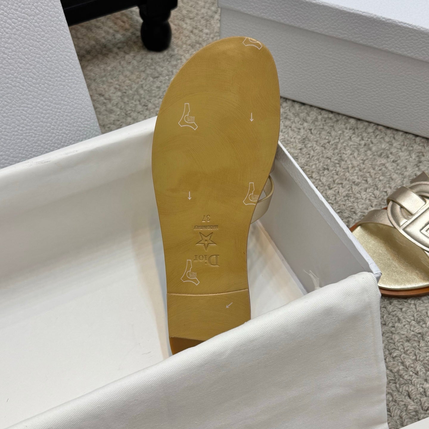 Dior gold sandal outsole with patterned grip marks and small symbol detailing