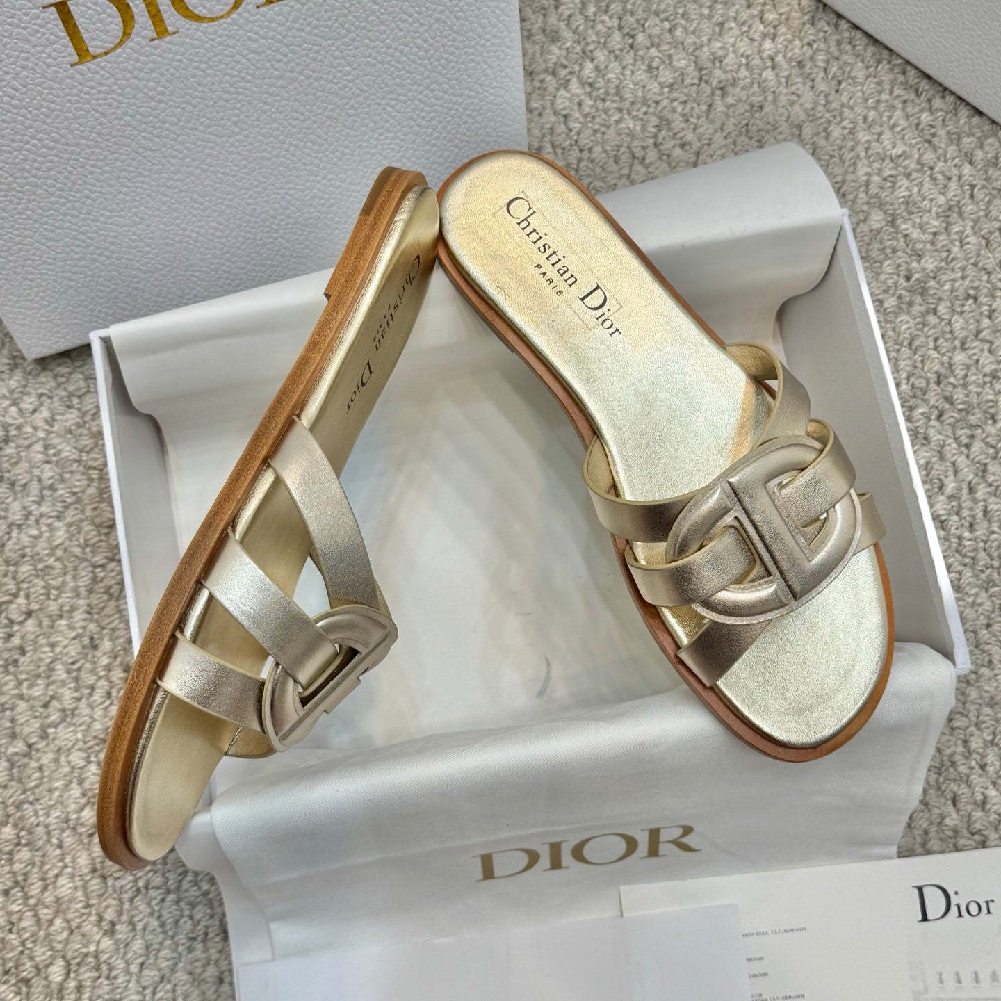 Dior gold slide sandals with metallic straps and tan rubber sole edge