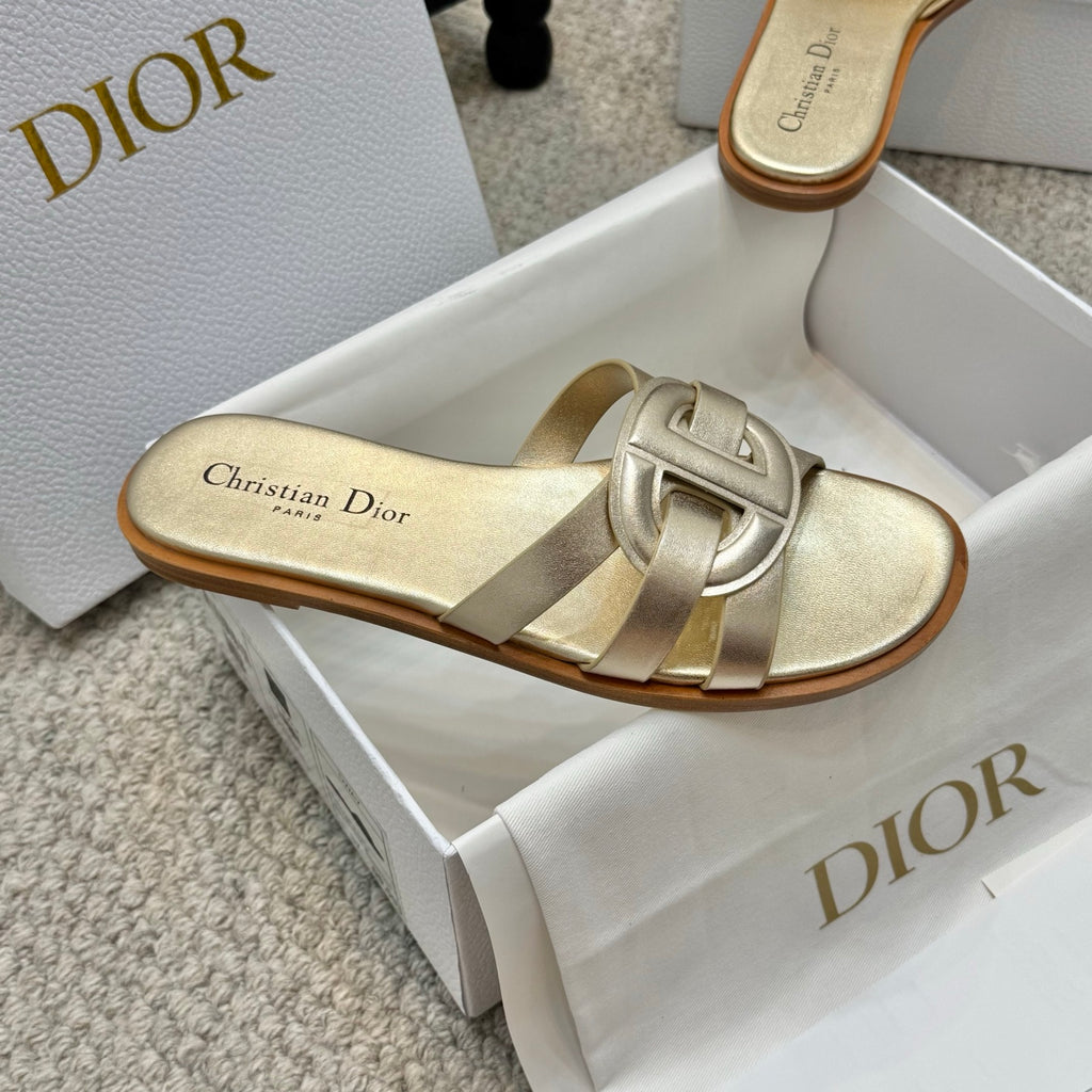 Dior gold mule slide sandals with sculpted buckle detail and low tan sole