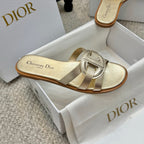 Dior gold mule slide sandals with sculpted buckle detail and low tan sole