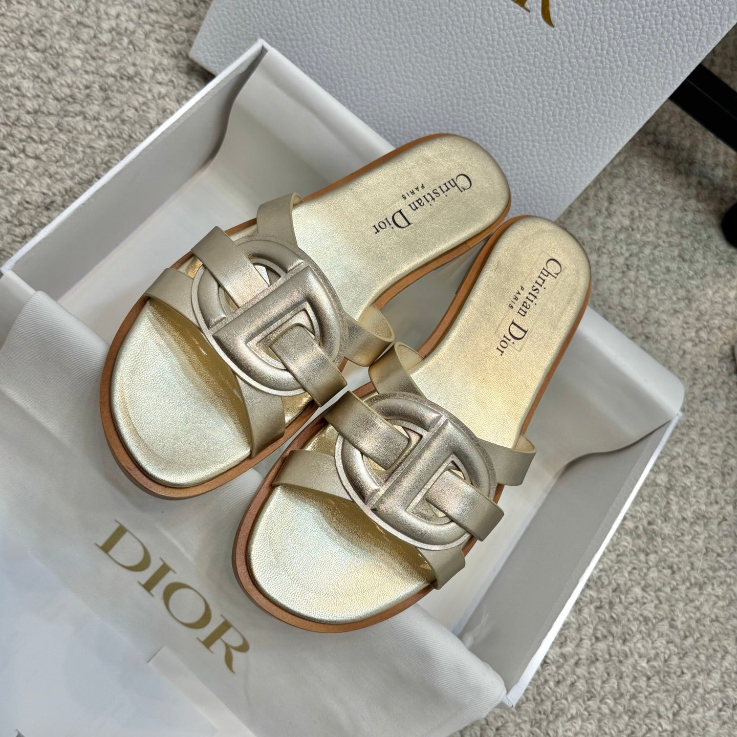 Dior gold slide sandals in box, featuring glossy strap and open-toe design
