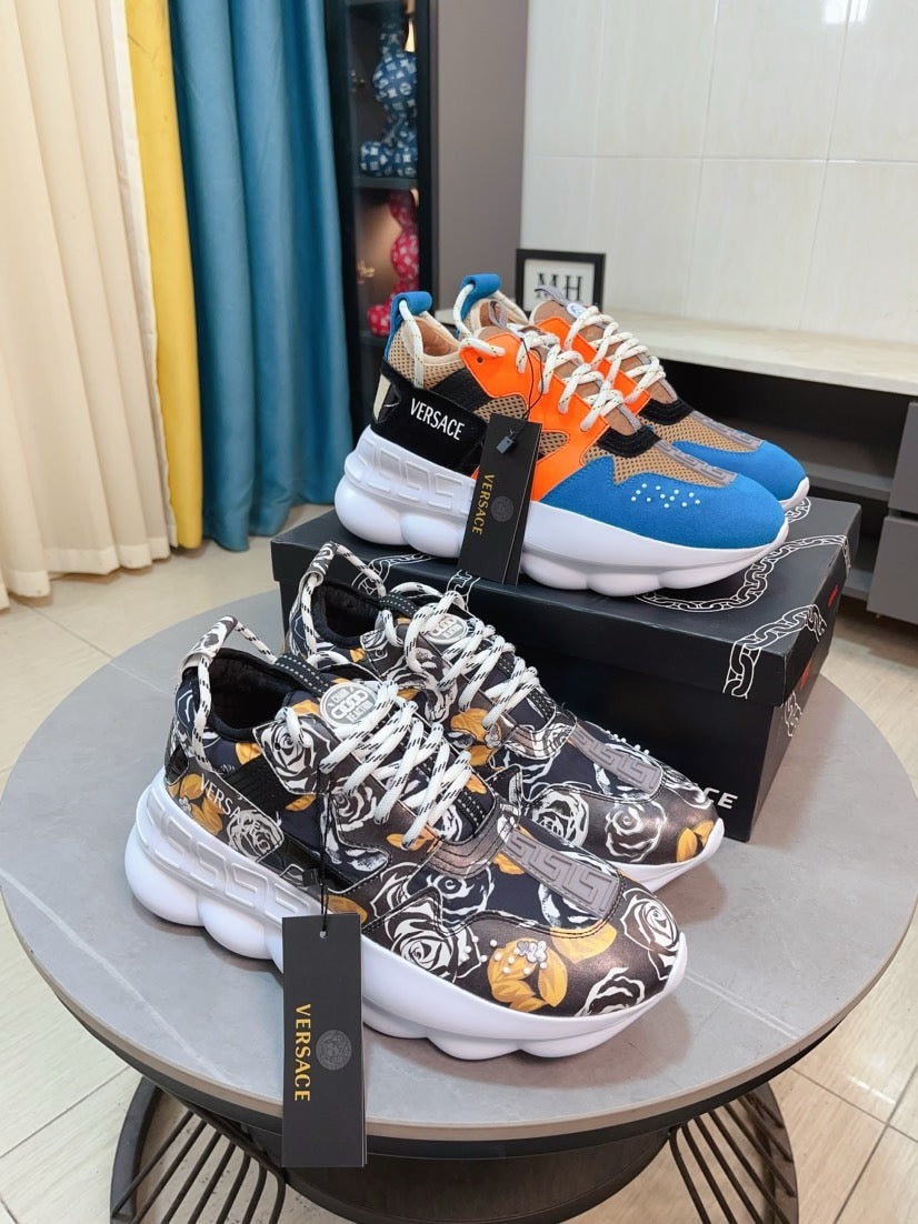 Colorblock sneaker with white sole, orange laces, blue and black upper, Versace logo