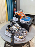 Colorblock sneaker with white sole, orange laces, blue and black upper, Versace logo
