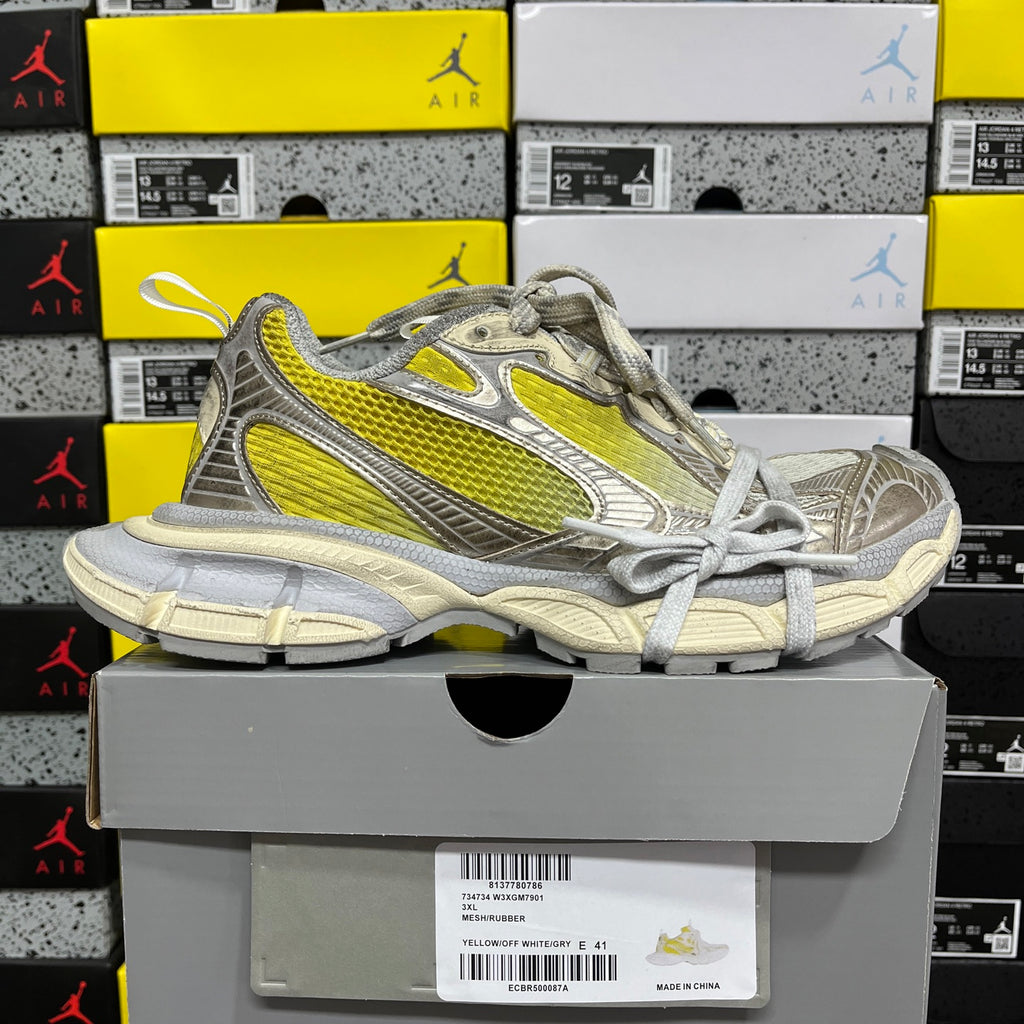 Balenciaga unisex sneakers on gray box, metallic gray with bright yellow stripe and laces