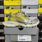 Balenciaga unisex sneakers on gray box, metallic gray with bright yellow stripe and laces