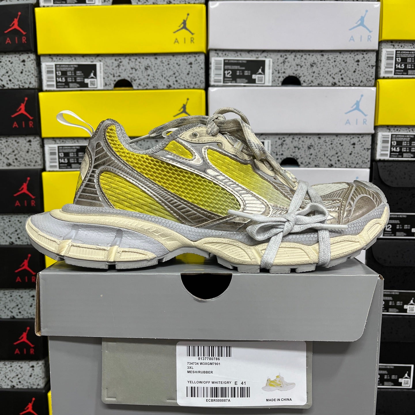 Balenciaga unisex sneakers on gray box, metallic gray with bright yellow stripe and laces