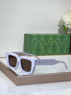 Gucci sunglasses with white frames and amber tinted lenses, oversized square shape