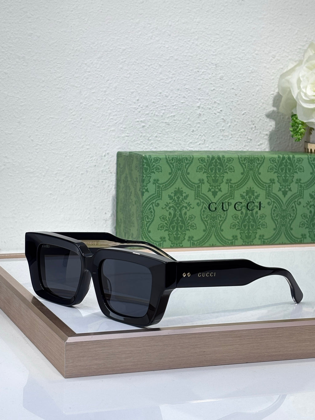 Gucci sunglasses with black frames and dark lenses, rectangular shape