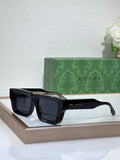 Gucci sunglasses with black frames and dark lenses, rectangular shape