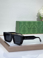 Gucci sunglasses with black frames and dark lenses, rectangular shape