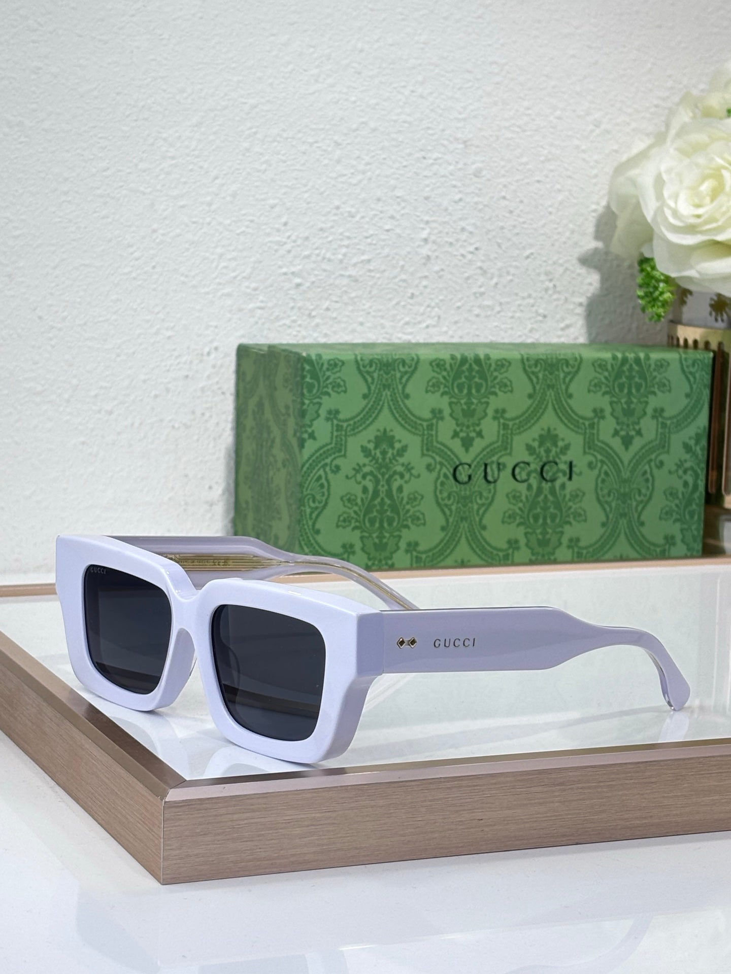 Gucci sunglasses with white frames and dark lenses, oversized square shape