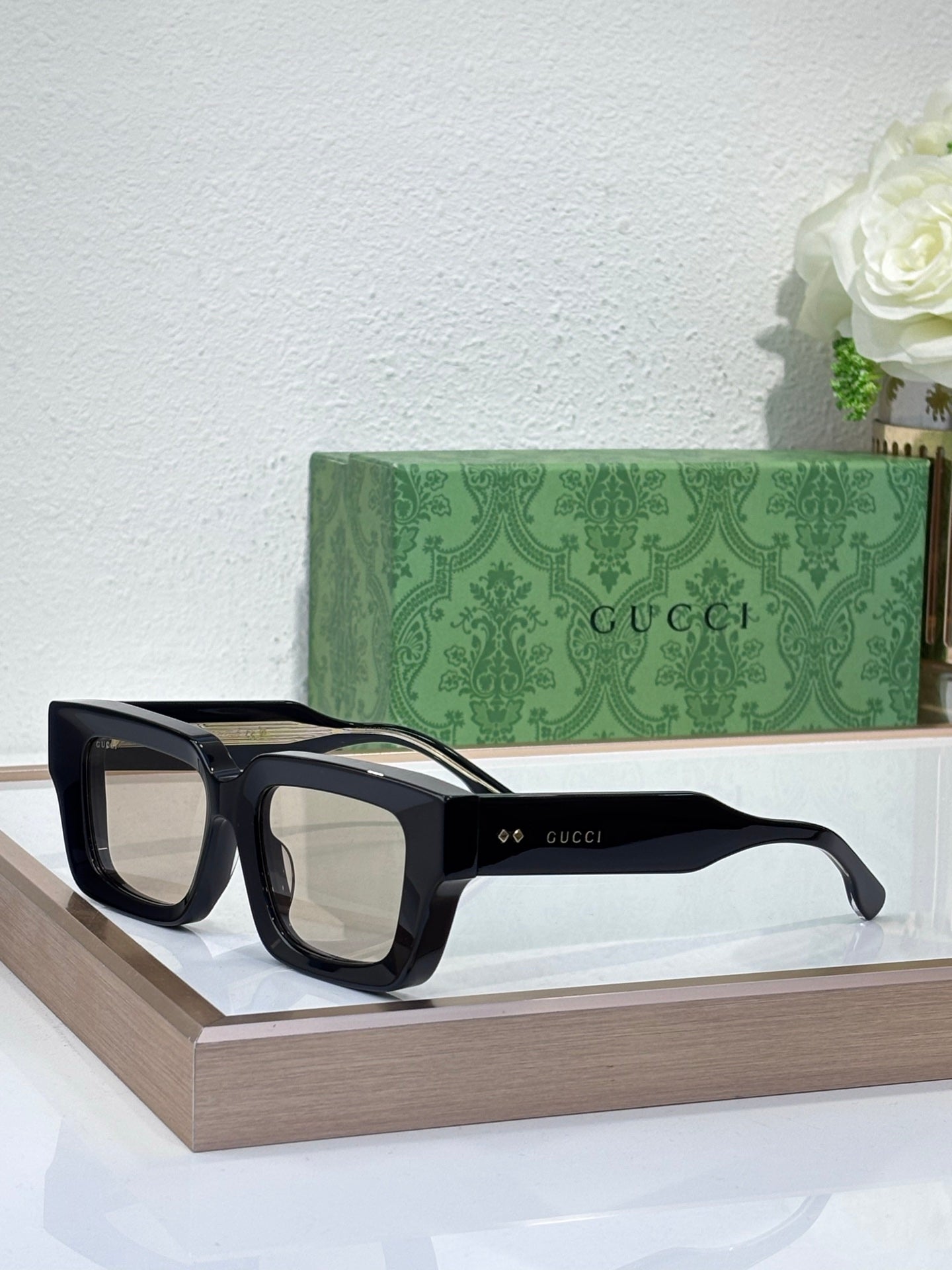 Gucci sunglasses with black frames and clear lenses, rectangular shape