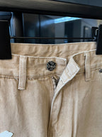 Khaki pants with decorative button waistband and fly opening, cross patch accents