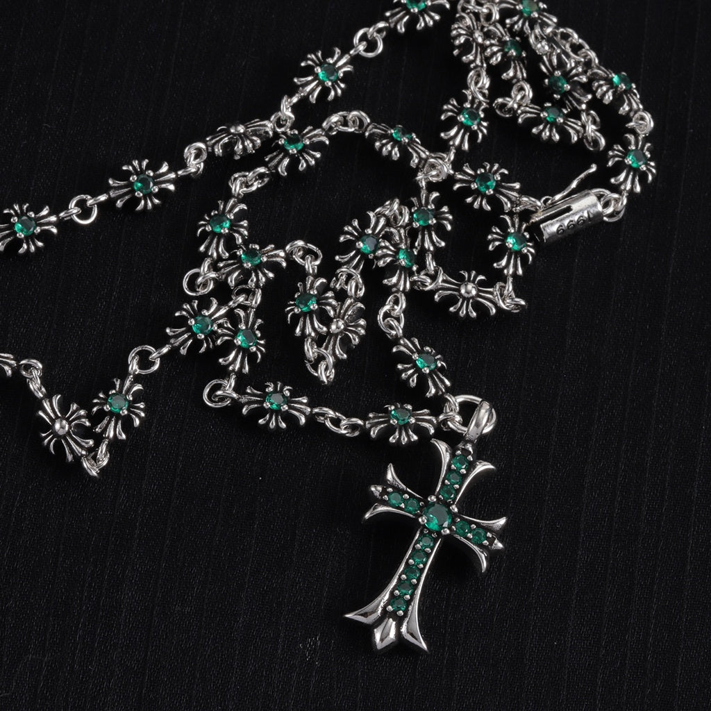 Silver cross charm necklace with teal-green flower station details