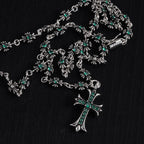 Silver cross charm necklace with teal-green flower station details
