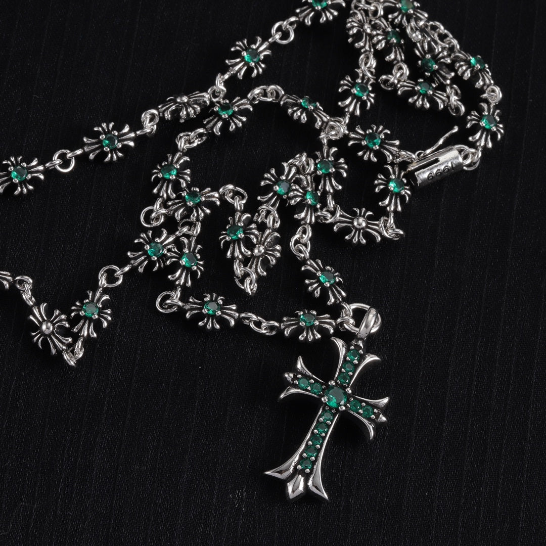 Silver cross charm necklace with teal-green flower station details