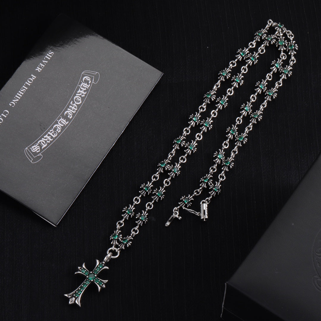 Silver cross pendant necklace with teal-green flower motif links