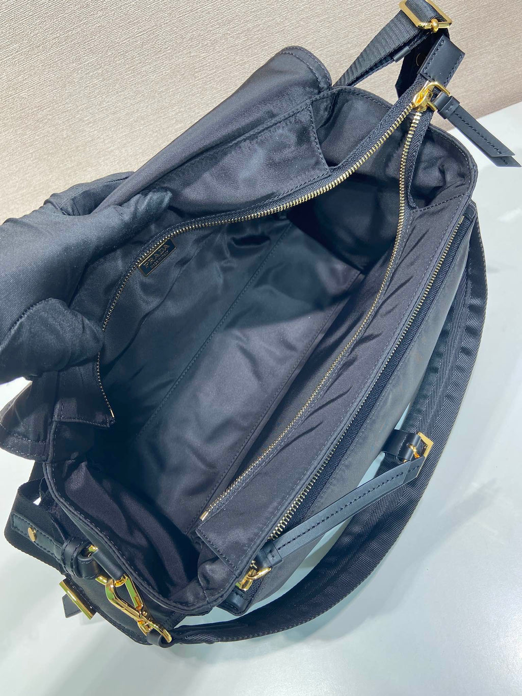 Prada nylon bag interior view, light blue-gray with zip pocket and lining