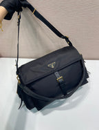 Prada nylon crossbody bag angled view, dark navy flap with gold buckle