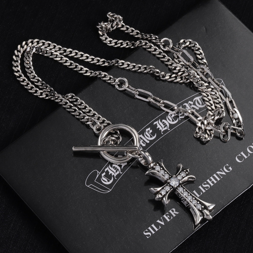 Silver-tone cross pendant necklace with oval ring clasp and gem accents