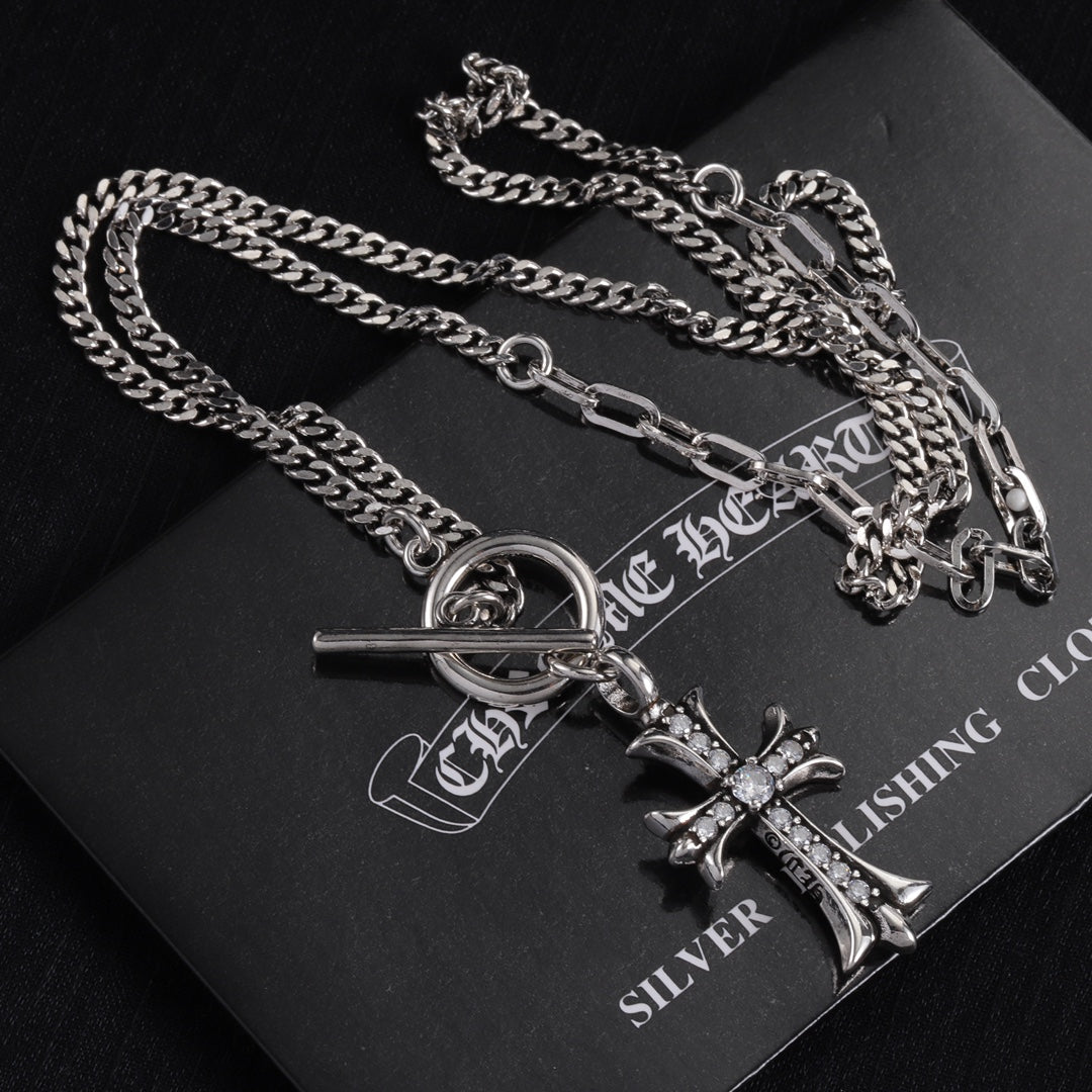 Silver-tone cross pendant necklace with oval ring clasp and gem accents