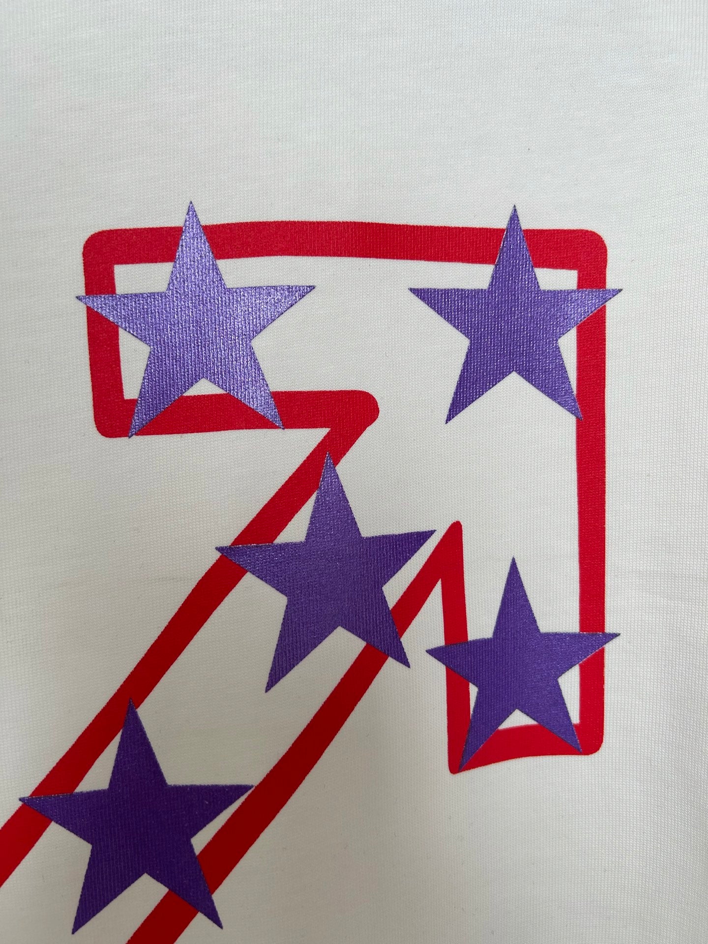 Off-White T-shirt graphic close-up with blue stars and red/blue rectangular outlines