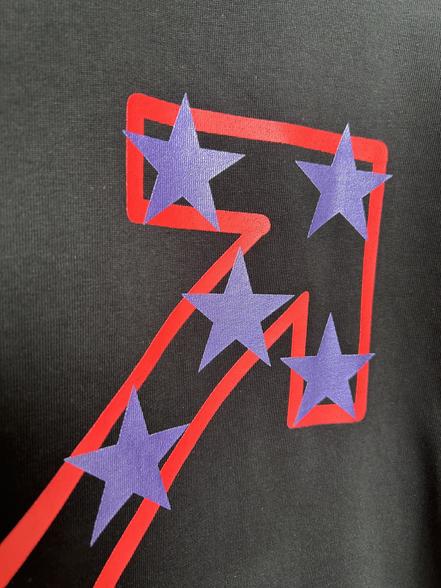 Off-White dark T-shirt with purple star graphic and red outline on the front.