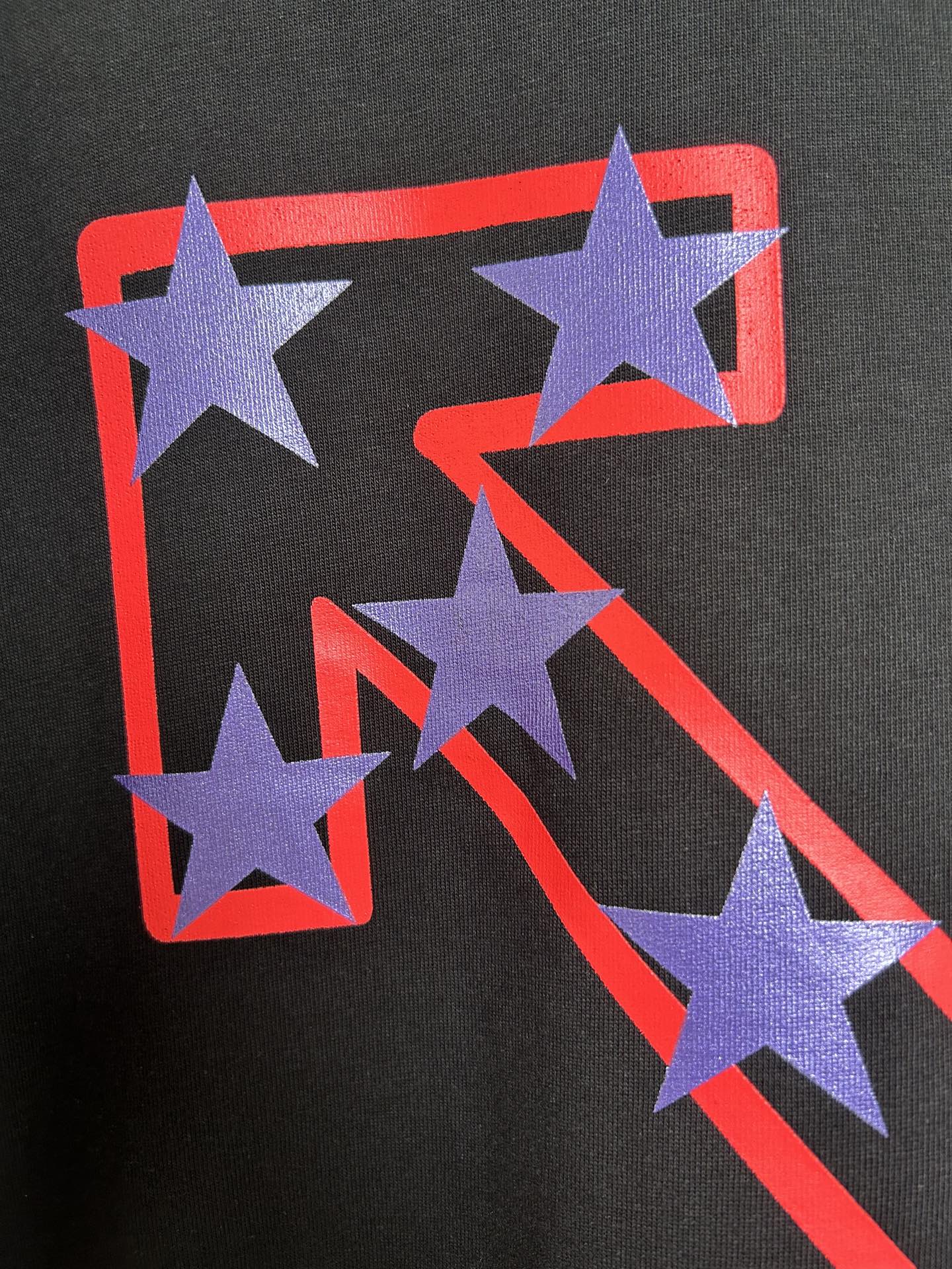 Off-White dark T-shirt featuring large purple star graphic with red-outlined shapes.