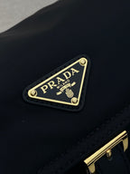 Prada logo plaque on dark navy crossbody flap with gold trim