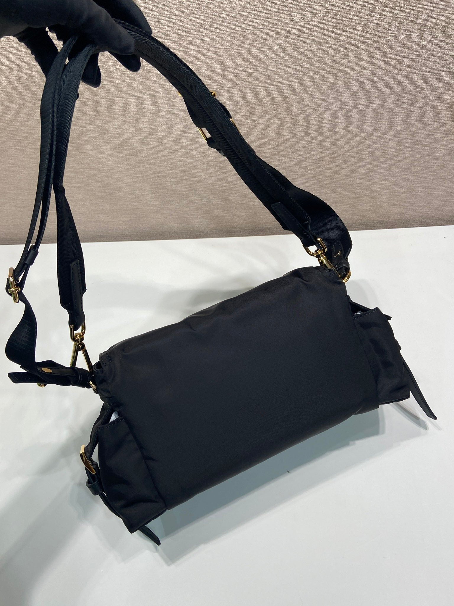 Prada crossbody bag, dark navy, back view with shoulder strap and side loops