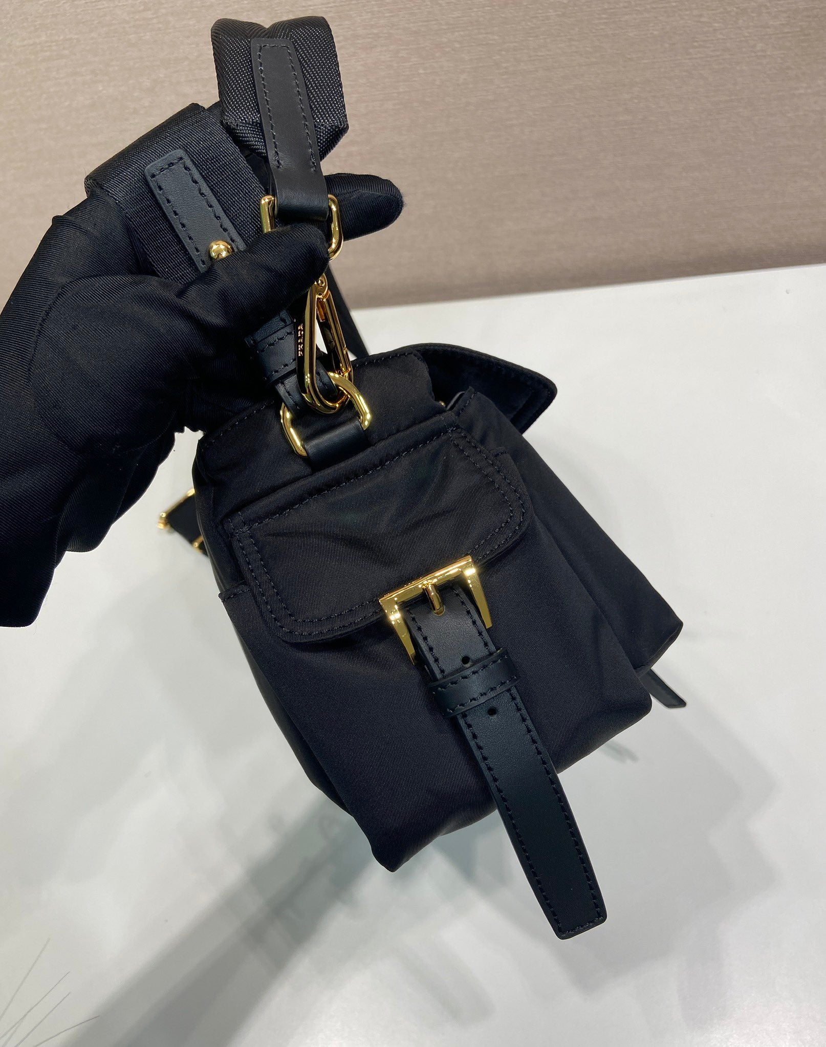 Prada crossbody bag, dark navy, close-up of top strap hardware and flap area