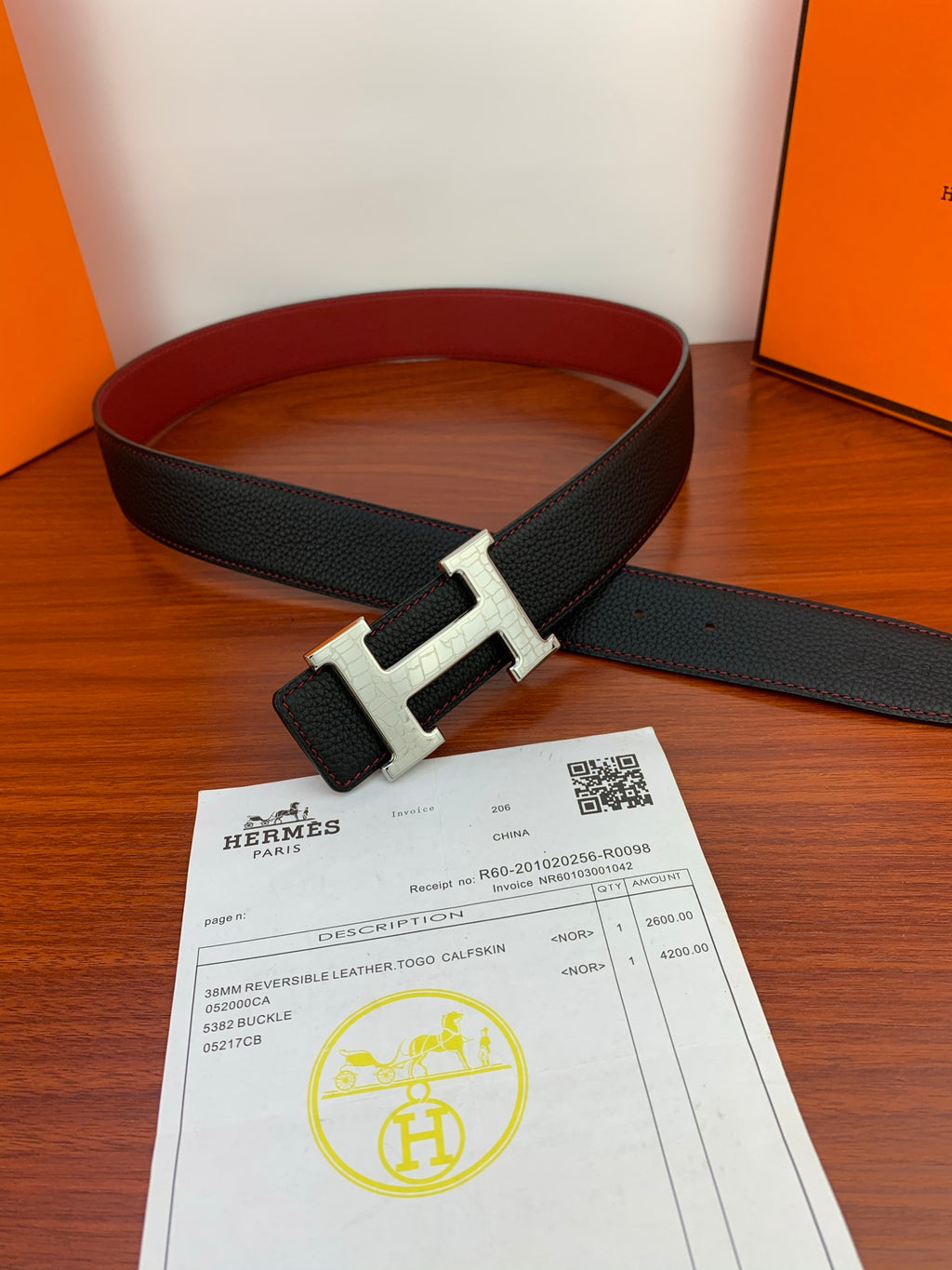 Hermes belt loop with black textured strap and silver buckle, shown with certificate card