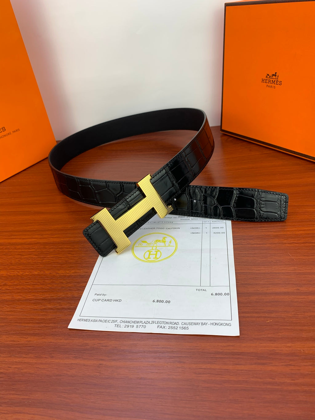 Hermes leather belt with dark strap and gold-tone H buckle, shown laid out