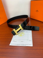 Hermes leather belt with dark strap and gold-tone H buckle, shown laid out