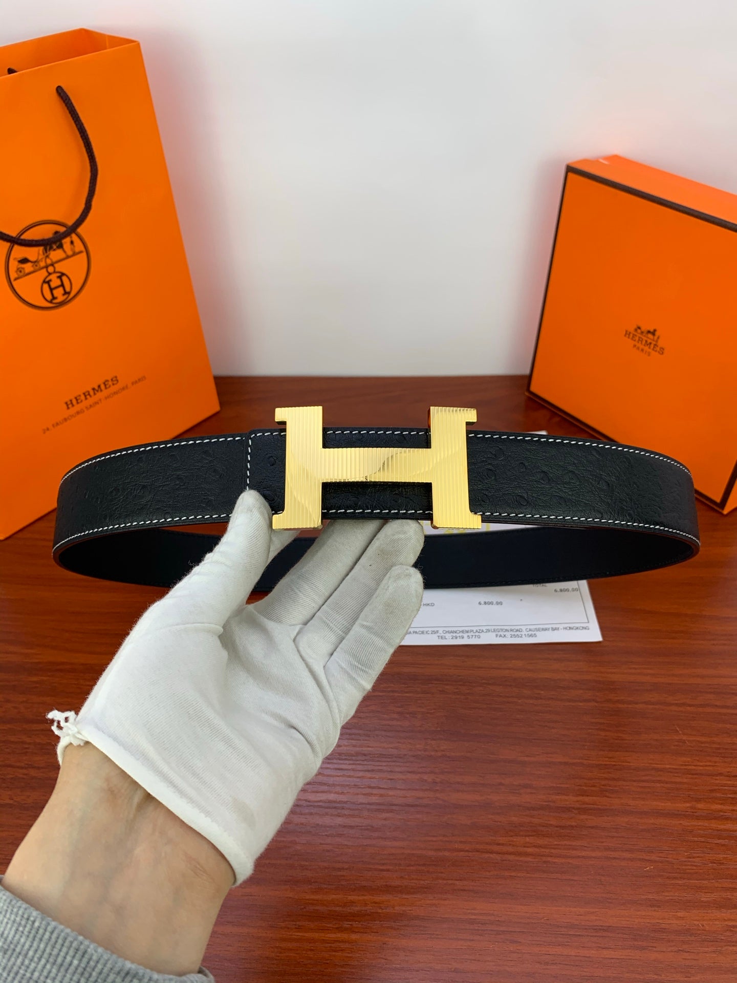 Hermes dark leather belt with gold H buckle and contrast stitching