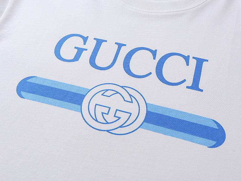 White T-shirt chest graphic with blue Gucci lettering and logo emblem