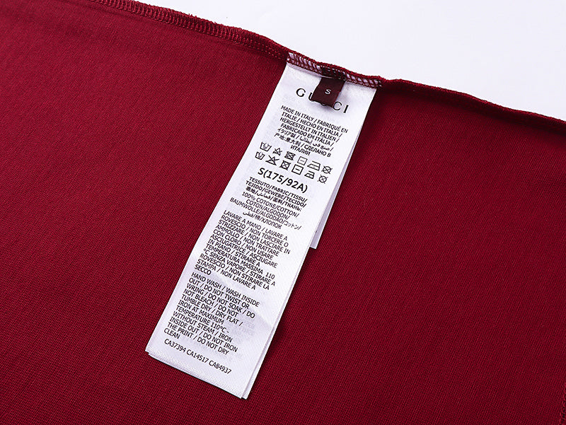 Burgundy Gucci T-shirt care label and size information at inner neck