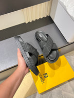 Gray slide sandals with textured outsole and wide crossover strap.