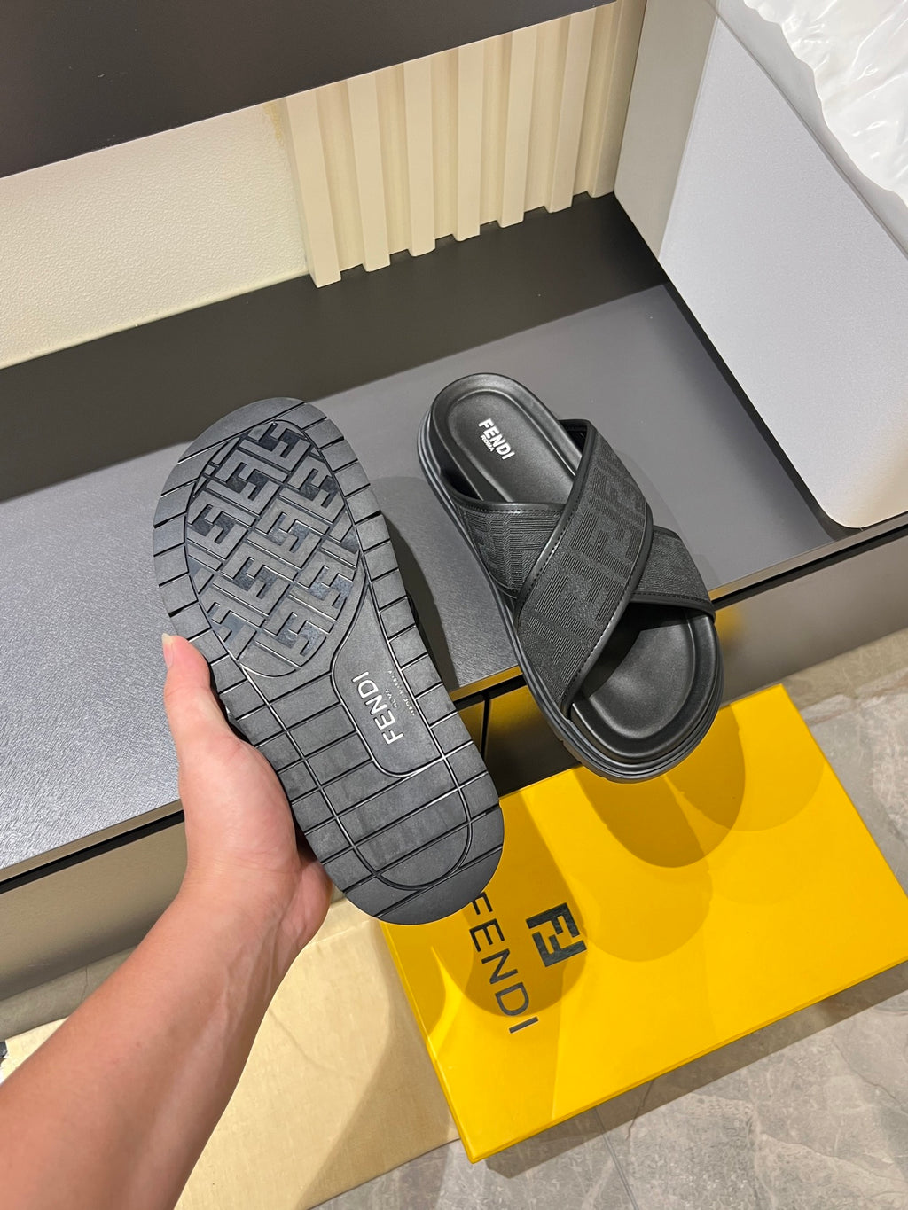 Gray Fendi sandals showing textured tread outsole and wide strap upper.