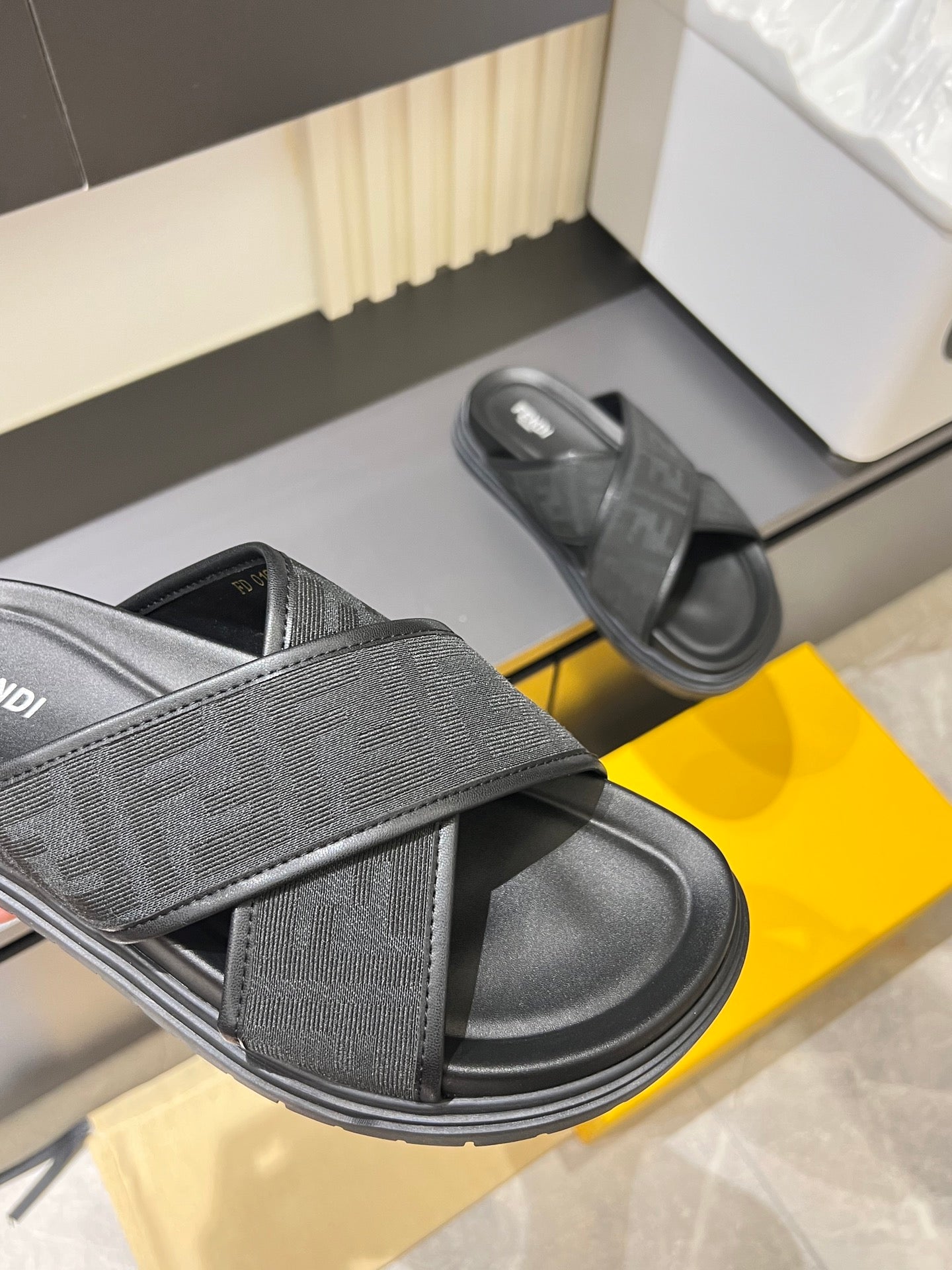 Gray Fendi slide sandals with wide cross strap and embossed logo insole.