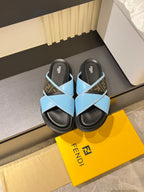 Fendi slide sandals with light blue cross straps and dark rubber soles, FF logo detail
