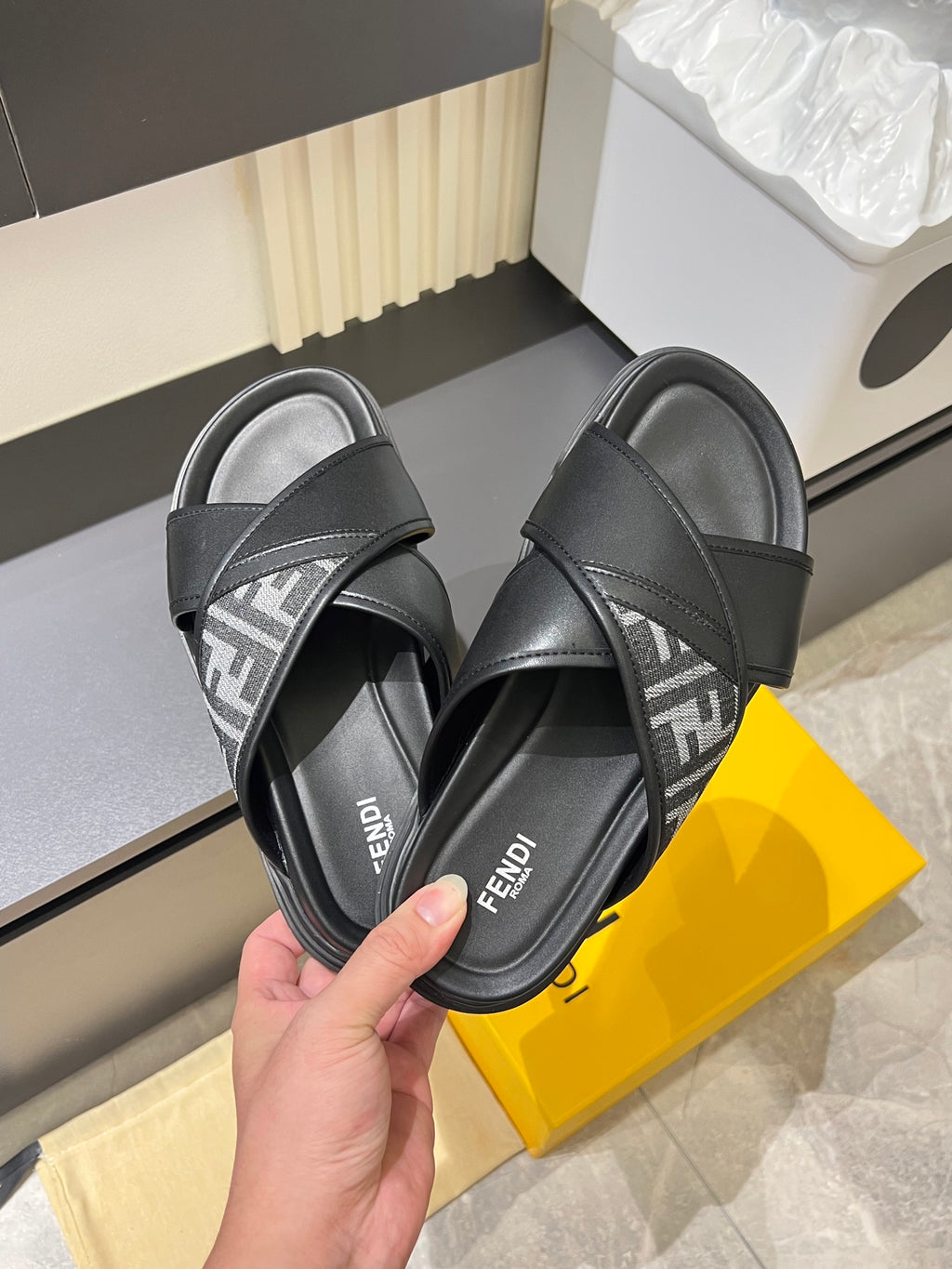 Black Fendi slide sandals close-up, crisscross strap with FF logo