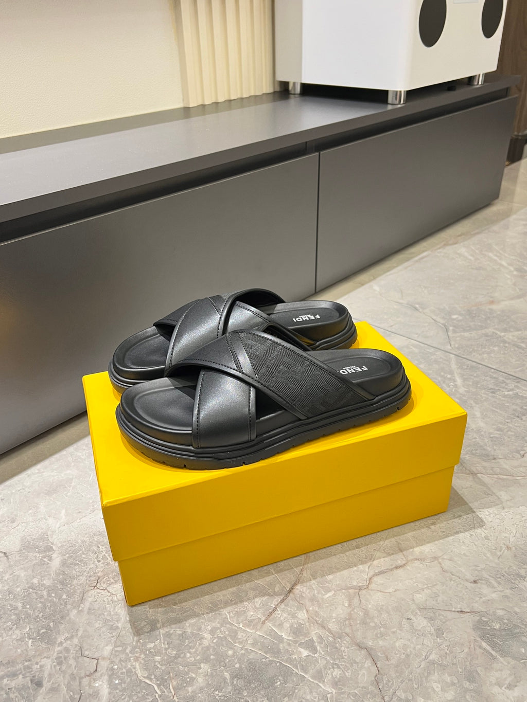 Black Fendi slide sandals with crossed leather straps and thick rubber outsole