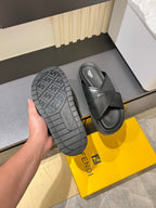Fendi black slide sandal outsole view with textured tread and side cross-strap