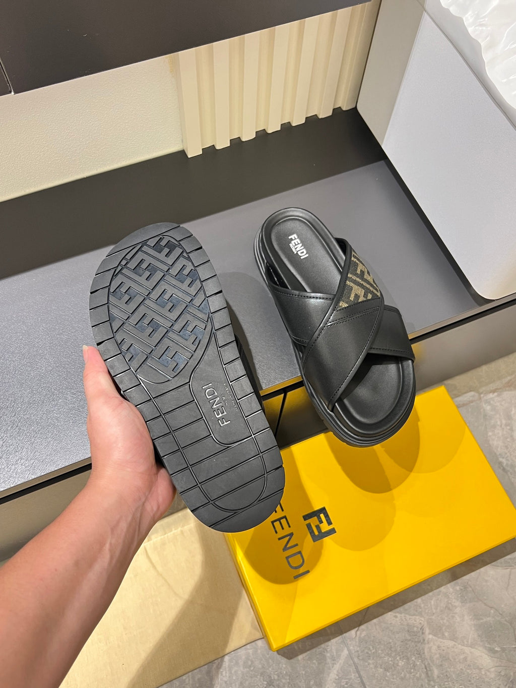 Fendi black slide sandals showing tread sole and FF-logo upper